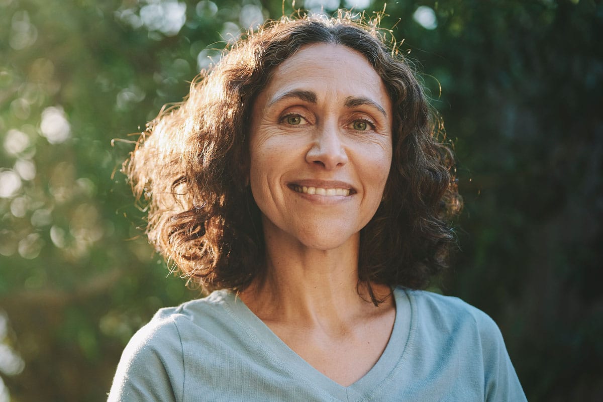 Woman smiling outside after a single dental implant in Van Nuys